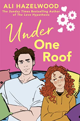 Book cover of 'Under One Roof' by Ali Hazelwood. The cover features an illustrated image of a young man and woman sitting closely together on a couch. The man has short dark hair and a serious expression, wearing a white shirt. The woman has curly red hair and a playful expression, wearing a yellow hoodie. They are surrounded by colorful pillows against a pink background. The title and author's name are displayed at the top of the cover, along with decorative white flower illustrations