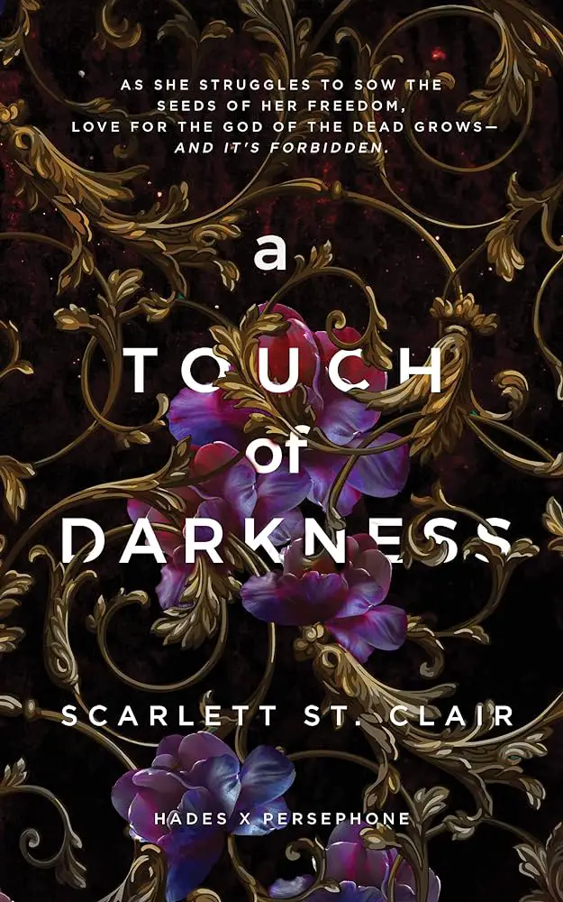 Book cover of A Touch of Darkness by Scarlett St. Clair, featuring a dark background with intricate golden vines and vibrant purple flowers. The title is centered in white, with a tagline at the top and the author's name at the bottom. The cover evokes themes of luxury, mystery, and forbidden love.








