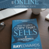 Book cover of 'How to Write Copy That Sells' by Ray Edwards on a wooden table with a laptop, coffee mug, and glasses, promoting free PDF download and online reading at Gyannidhi.com